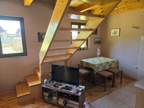 un salon avec un escalier en bois et une table dans l'établissement Enchanting chalet amidst impressive nature, à Žabljak