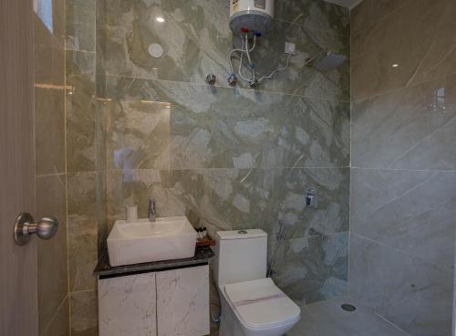 a bathroom with a toilet and a sink at Perfectstayz Value Alpine Near Laxman Jhula in Rishīkesh