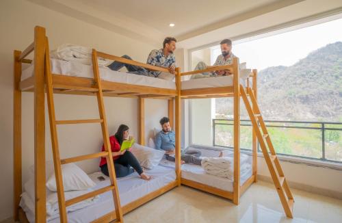 a group of people standing in a room with bunk beds at Perfectstayz Value Alpine Near Laxman Jhula in Rishīkesh