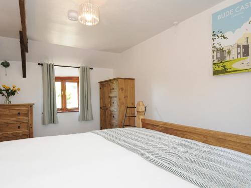 a bedroom with a white bed and a window at West Lee in Bude