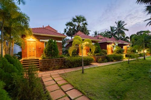 a house with a lawn in front of it at Nathan Resort with Swimming Pool in Puducherry