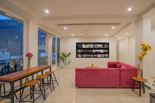 a living room with a red couch and a bar at Perfectstayz Value Alpine Near Laxman Jhula in Rishīkesh