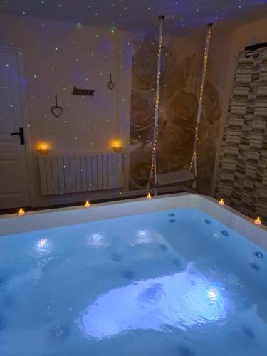 a bath tub with lights in a room with a ceiling at Les suites d'Élise - Gîte Agathe in Grumesnil