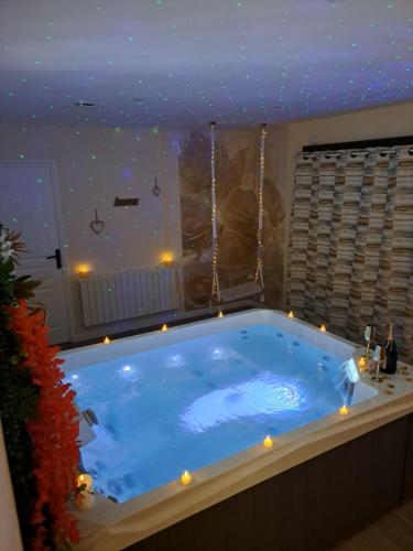 a large blue tub with lights in a room at Les suites d'Élise - Gîte Agathe in Grumesnil