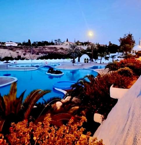 a view of a resort with blue water and plants at Vivienda en El Campello playa in El Campello