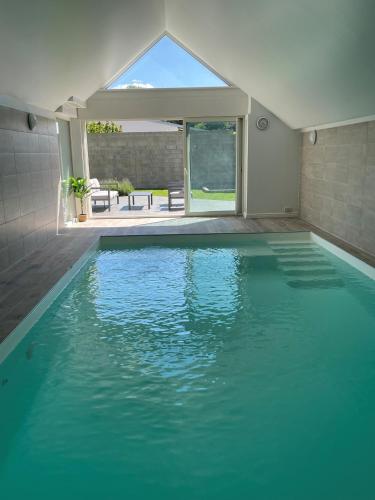 une piscine avec de l'eau bleue dans une maison dans l'établissement Villa de standing en Champagne, à Fresnes-lès-Reims