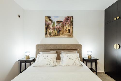 a bedroom with a bed with a painting above it at Albizia in Herceg-Novi