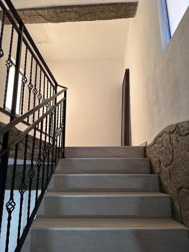 a staircase in a house with a stone wall at Pensiunea CASA VISELOR in Sviniţa
