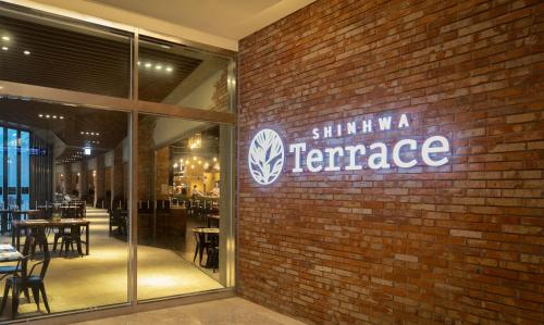 a brick wall with a sign that reads shhh wa terrace at Shinhwa Jeju Shinhwa World Hotels in Seogwipo