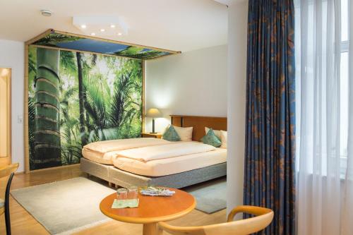 バート・ヘルスフェルトにあるホテルペンション ビタリスのベッドとテーブルが備わるホテルルームです。