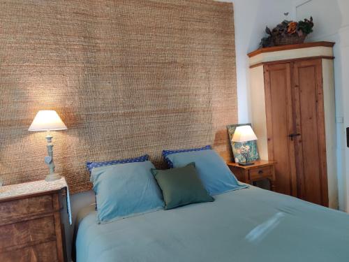 Un dormitorio con una cama azul con dos almohadas. en Le Cerisier, en Mareil-Marly