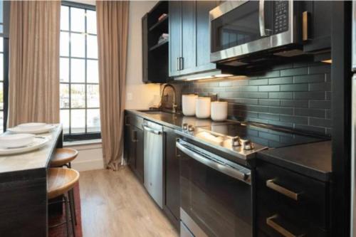 a kitchen with black cabinets and a counter top at 1 Bedroom apt suite Wifi fitness room Deep Ellum-FIFA WORLD CUP 2026 in Dallas
