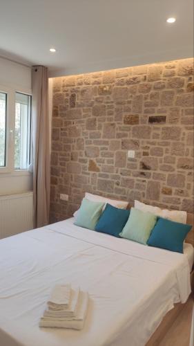 a bedroom with a large bed with a brick wall at Gea luxury apartment Myrina 2 in Myrina