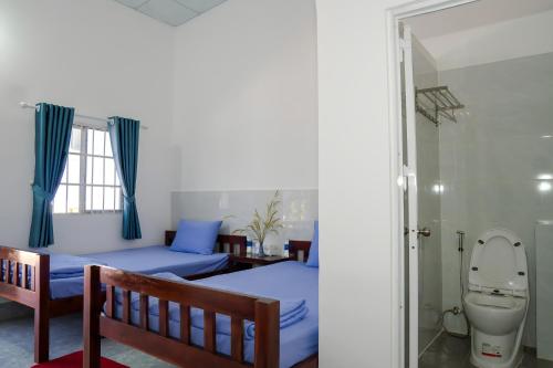 a bedroom with two beds and a toilet at Nhà Nghỉ Vườn Oải Hương LAVENDER GARDEN GUEST HOUSE in Phu Quoc