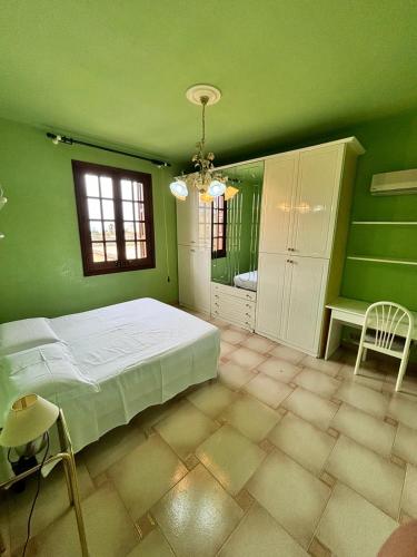 a green bedroom with a bed and a window at Appartamento villa Francesca in Castelluzzo