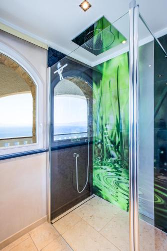 a shower in a room with a glass wall at Villa Sun Rock - Ravdoucha in Kolymvari