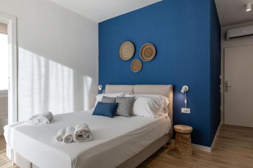 a blue bedroom with a bed with towels on it at Delphis Pula Rooms in Pula