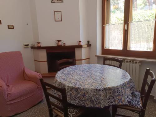 a dining room with a table and chairs and a fireplace at Casa Azzurra in Montefiore dellʼAso
