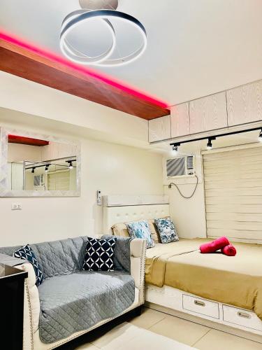 a living room with a couch and a bed at Avida Towers Riala Tower inside IT Park Cebu City in Cebu City