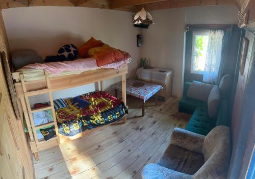 a room with two bunk beds and a chair at Domek letniskowy Borówno Wielkie 32 in Skarszewy
