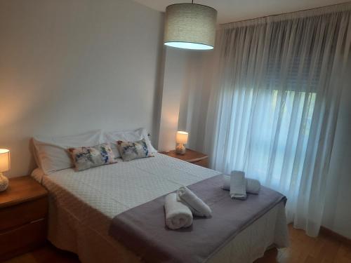 a bedroom with a bed with towels on it at NextGarden in Padrón