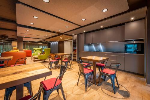 a restaurant with tables and chairs and a kitchen at Los Lorentes Apartments Bern City in Bern