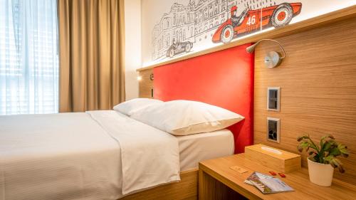 a hotel room with a bed and a red wall at Los Lorentes Apartments Bern City in Bern