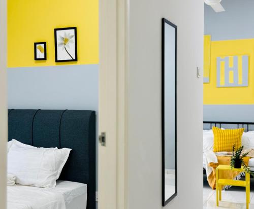 a bedroom with a bed and a yellow wall at The Sun 1 or 3BR Bayan Lepas 4 to 10 pax WL in Bayan Lepas