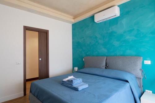 Un dormitorio con una cama con una pared azul. en Domus DiDio, en Roma