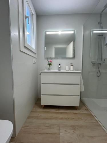 a white bathroom with a sink and a mirror at Deluxe Familiar - Apartamentos Birdie in Albacete