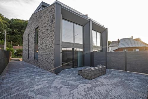 a brick house with glass doors on a patio at MARVEL apartamentai in Kaunas