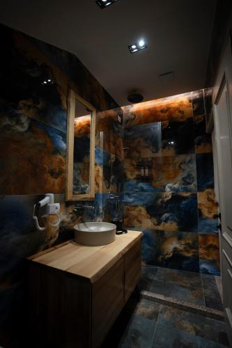 a bathroom with a sink and a large mural at Hotel Jezerca Theth in Theth