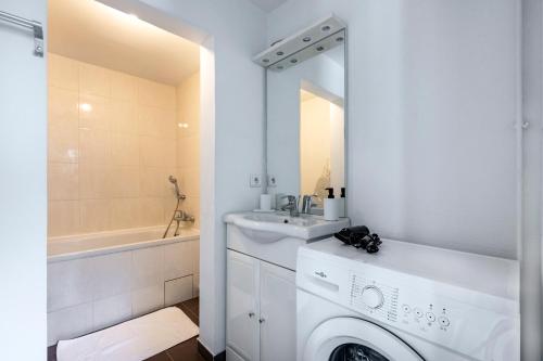 La salle de bains blanche est pourvue d'un lavabo et d'un lave-linge. dans l'établissement Close to Center of Paris I Fully equipped, à Paris