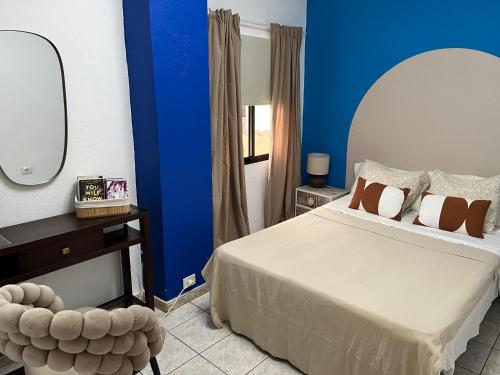een slaapkamer met een bed en een blauwe muur bij CORNELIAS HOME 5A playa in Los Cristianos