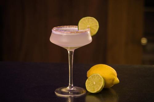 a drink in a glass with a lemon on a table at Boutique Hotel Planlim in Ortisei