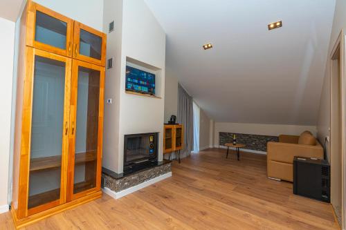a living room with a fireplace and a couch at Hotel Jezerca Theth in Theth