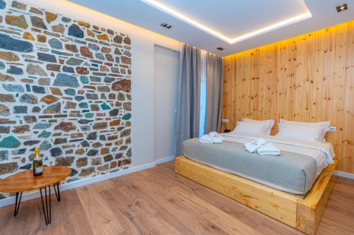 a bedroom with a bed and a stone wall at Hotel Jezerca Theth in Theth