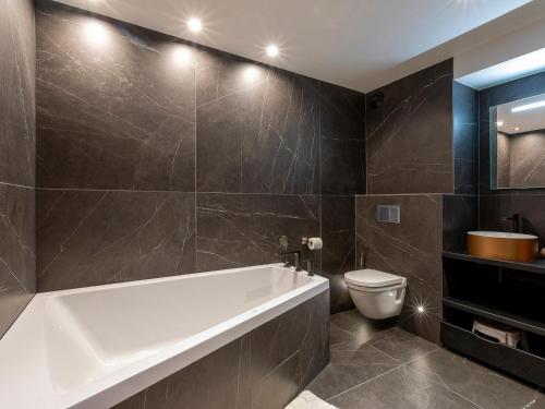 une salle de bain avec baignoire et toilettes dans l'établissement Duplex rénové 2019, 8 pers, balcon, Avoriaz - FR-1-314-232, à Morzine