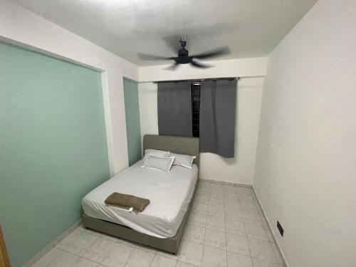 a bedroom with a bed with a ceiling fan at Blissful Breeze 4 ROOMS & NETFLIX by EZYROOM MELAKA in Ayer Keroh