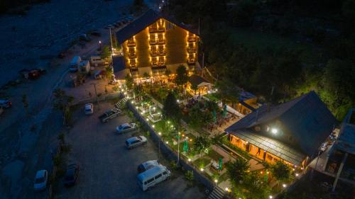 an overhead view of a building with parked cars and lights at Hotel Jezerca Theth in Theth