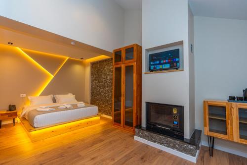 a bedroom with a bed and a fireplace and a tv at Hotel Jezerca Theth in Theth