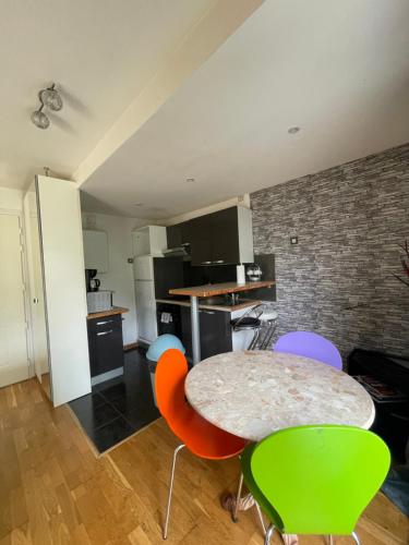 une cuisine avec une table et des chaises dans une pièce dans l'établissement Appartement cosy et spacieux avec une belle vue sur jardin, proche des commodités et à moins de 30 minutes de Paris en transport, à Chennevières-sur-Marne