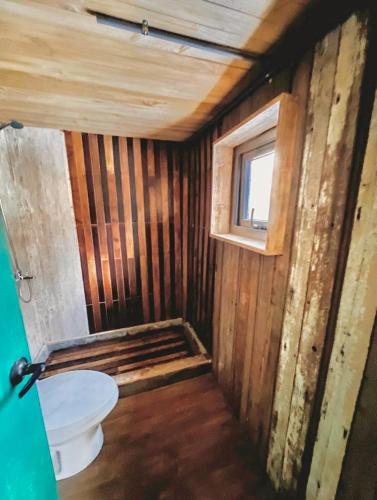 a small bathroom with a toilet and a window at Casa Bosque Patagonia in Villa Cerro Castillo