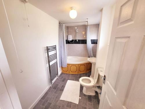 a bathroom with a toilet and a sink and a tub at Stunning! 3 Bed Entire House with Free Parking in Stapleford