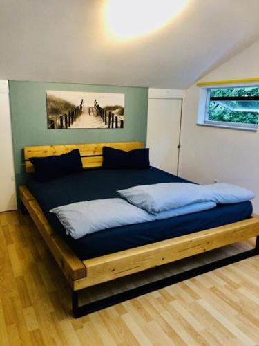 a bed in a bedroom with a painting on the wall at OstseeFreiheit in Bodstedt