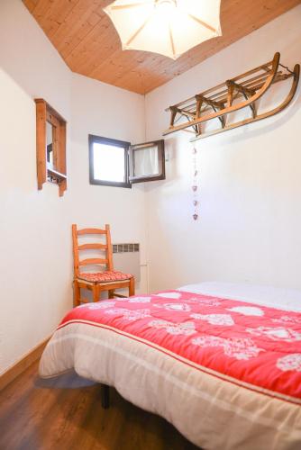 une chambre avec un lit et une chaise dans l'établissement VALLOIRE - Les Verneys - Thymel, à Valloire