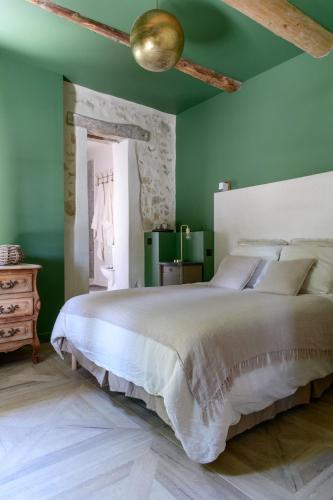 a bedroom with a large bed and green walls at Maison d'hôtes La Datcha in Manosque