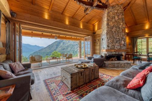 a living room with a stone fireplace and a large window at Villa Cassia in Stazzona