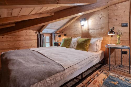 a large bed in a room with wooden walls at Villa Cassia in Stazzona