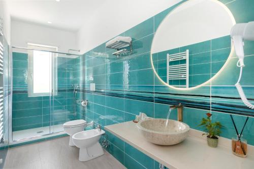 a bathroom with a sink and a toilet and a mirror at Hotel Desiree in Sorrento